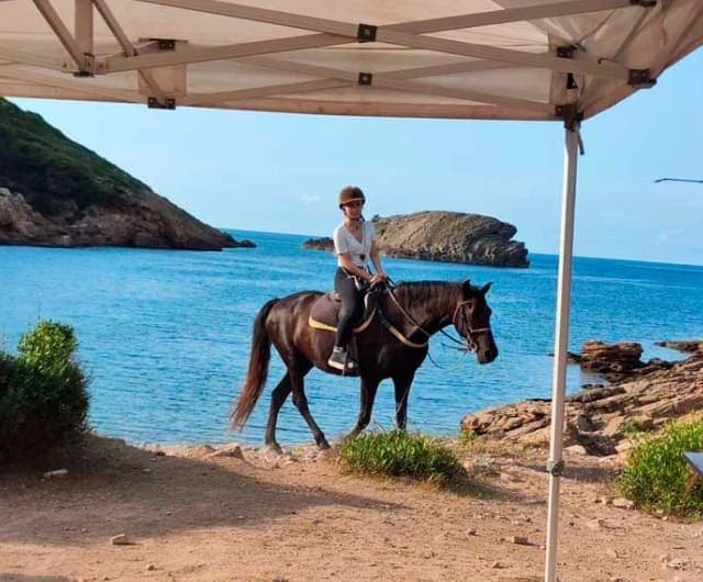 Ruta a caballo junto al mar con aperitivo típico de Menorca.